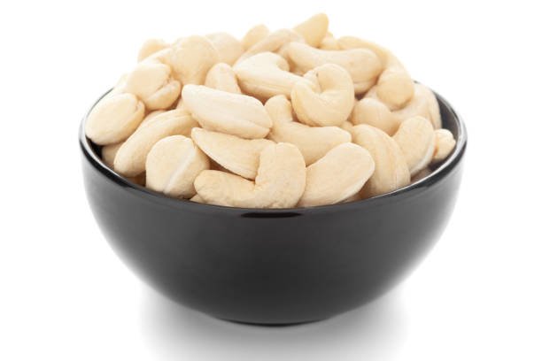 Close-up Organic dry fruit cashew nut (Anacardium occidentale) in black ceramic bowl on white background